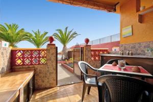 a patio with a table and chairs and palm trees at Casa Anpi in Costa de Antigua
