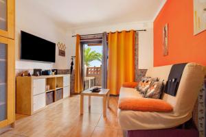 a living room with a couch and a tv at Casa Anpi in Costa de Antigua