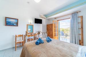 a bedroom with a bed with blue towels on it at Captain Spiros Studios in Paleokastritsa