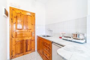 a kitchen with a sink and a wooden door at Captain Spiros Studios in Paleokastritsa +13 photos