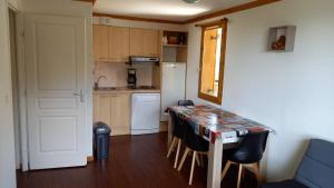 a kitchen with a table and chairs in a room at Appartement Le Maevan in Vassivière