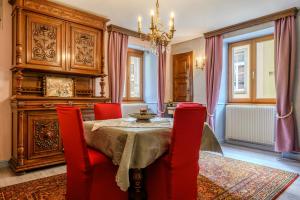 a dining room with a table and red chairs at Gîte Le Rempart in Guebwiller
