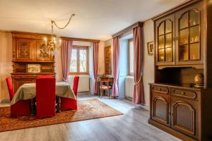 a dining room with a table and a red chair at Gîte Le Rempart in Guebwiller