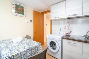 a kitchen with a washing machine and a table at Il cappello sulle 23 in Avola