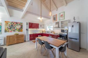 a kitchen with a wooden table and a refrigerator at Capriccio Mediterraneo in Sassari