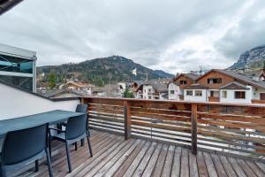 a balcony with a table and chairs on a wooden deck at Ciasa Irene App Mansarde in La Villa