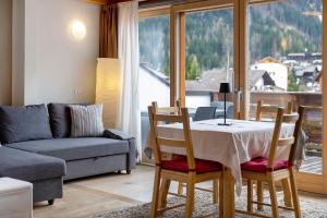 a living room with a table and a couch at Ciasa Irene App Mansarde in La Villa