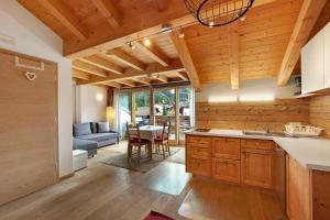 a kitchen and living room with a couch and a table at Ciasa Irene App Mansarde in La Villa +11 photos