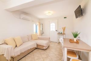 a living room with a couch and a table at Anemologio 302 Tinos in Agios Ioannis