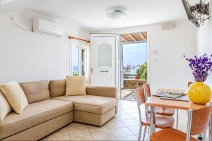 a living room with a couch and a table at Anemologio 302 Tinos in Agios Ioannis
