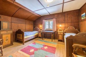 a bedroom with two beds and a desk and a window at Haus Löweneck in Bayrischzell