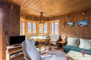 a living room with a couch a table and a tv at Haus Löweneck in Bayrischzell