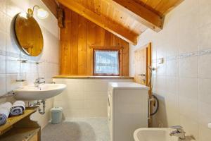 a bathroom with a sink and a toilet and a mirror at Plazores in San Vigilio Di Marebbe +38 photos