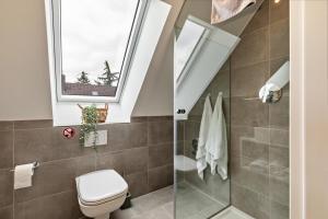 a bathroom with a toilet and a window at Fewo Parkside S5 - 8Min Legoland in Günzburg +17 photos
