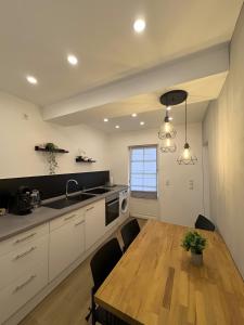 a kitchen with a wooden table and a dining room at C & D Wohnung I in Bad Kissingen +7 photos