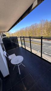 a balcony with a table and a view of a highway at Apartament Wiosenna in Białystok