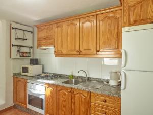 a kitchen with wooden cabinets and a white refrigerator at Finca La Calerita D in Uga