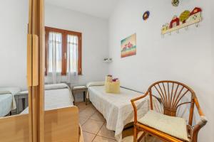 a room with two beds and a chair in it at Sole Mare di Barbara in Chia