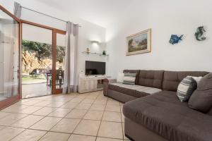 a living room with a couch and a tv at Sole Mare di Barbara in Chia