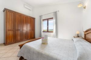 a bedroom with a large bed and a window at Sole Mare di Barbara in Chia