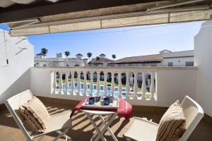 a patio with a table and chairs on a balcony at Casa Costa Ballena Dahlia in Costa Ballena