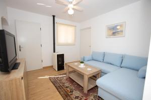 a living room with a blue couch and a table at La Casita in San Vicente del Raspeig