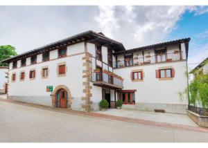 a large white building with balconies on a street at Apartamento ll in Iráizoz +5 photos