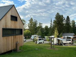 a barn with vehicles parked in a parking lot at PRIMÁTOR CAMPING RESORT LITOMYŠL in Litomyšl