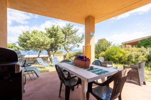a table and chairs on a patio with a grill at Villa Alba in Costa Paradiso