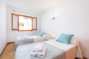 two beds in a room with a window at Es Pujol in Alcudia