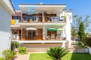 a building with chairs and umbrellas on the balcony at Es Pujol in Alcudia
