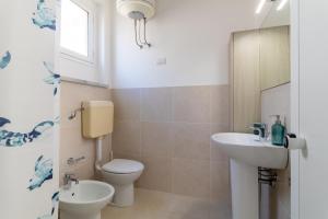 a bathroom with a toilet and a sink at Brezzadisudest in Marina di Ragusa +17 photos