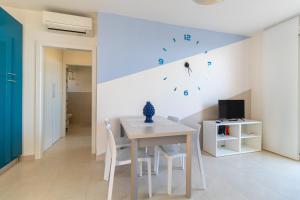 a white dining room with a white table and chairs at Brezzadisudest in Marina di Ragusa