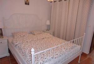 a bedroom with a white bed with a white crib at Townhouse Almunecar Old Town in Almuñécar