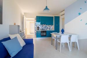 a blue kitchen with a blue couch and a table at Brezzadisudest in Marina di Ragusa