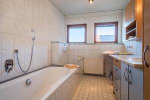 a bathroom with a tub and a shower and a sink at Ferienhof Sauter Friedrichshafen in Neukirch +22 photos