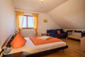 a bedroom with a bed and a blue couch at Ferienhof Sauter Friedrichshafen in Neukirch