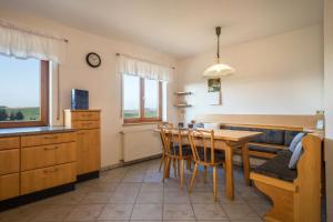 a kitchen with a table and chairs in a room at Ferienhof Sauter Friedrichshafen in Neukirch