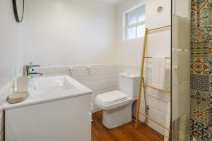 a white bathroom with a toilet and a sink at Adega Peróla in Cais do Galego +16 photos