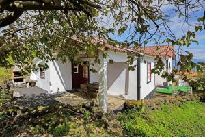 a small white house with a red door at Adega Peróla in Cais do Galego