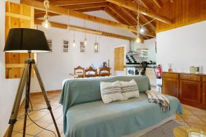 a room with a couch with a lamp and a kitchen at Adega Peróla in Cais do Galego