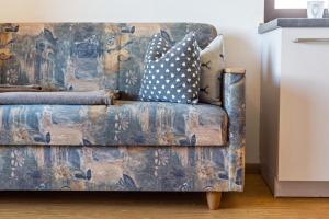 a blue couch with polka dot pillows on it at Gatscherhof Apt Abendrot in Luson