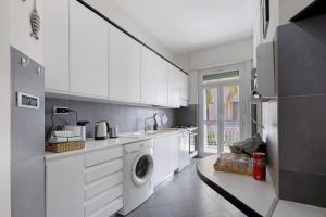 a kitchen with white cabinets and a washing machine at Casa vacanze Brezza di Levante in Sestri Levante +17 photos