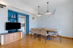 a dining room with a table and a flat screen tv at Casa vacanze Brezza di Levante in Sestri Levante