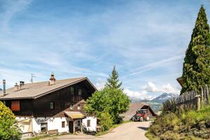a large wooden house with a fence and trees at Gatscherhof Apt Abendrot in Luson