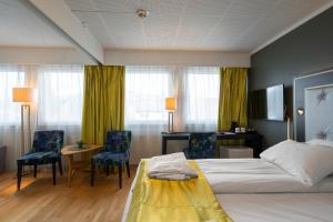 a hotel room with a bed and a desk and chairs at Thon Hotel Sortland in Sortland