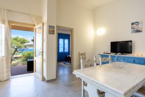 a living room with a table and a tv at Villa Alba in Costa Paradiso