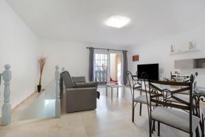a living room with a couch and a table and chairs at Casa Yeray in Caleta De Fuste