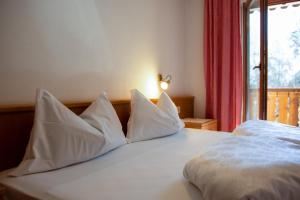 a white bed with white pillows and a window at Apartment 3 - Zur Sonne in Laion