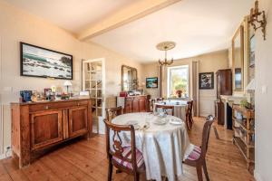 a kitchen and dining room with a table and chairs at La Demeure Océane in Portsall